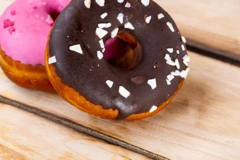 Two raspberry and chocolate donuts on a wooden background. Free space for tex Foto stock