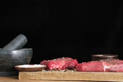 Two raw beef and spices salt and pepper seasoning Stock Photos