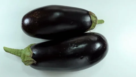 Two raw eggplant rotates on a white Video stock 134727881