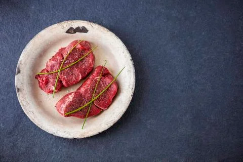 Two raw filet steaks on an old plate with a slate background Stock-Fotos