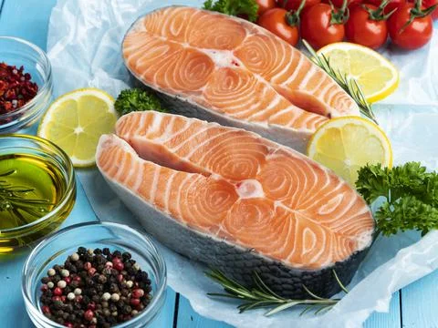 Two raw fresh steak fish trout, salmon and spices on a blue wooden background Stock Photos