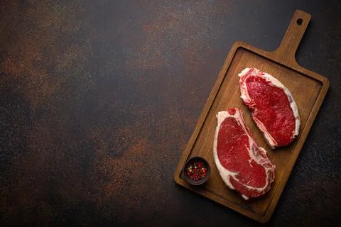 Two raw meat beef rib eye marbled steaks on wooden cutting board Stock-Fotos