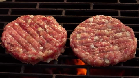 Two raw meat burger cutlet with onions are grilling above the open fire Video stock 144176003