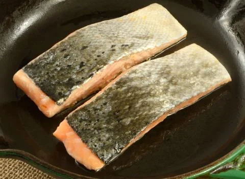 Two raw salmon fish fillets skin side up in frying pan Stock Photos