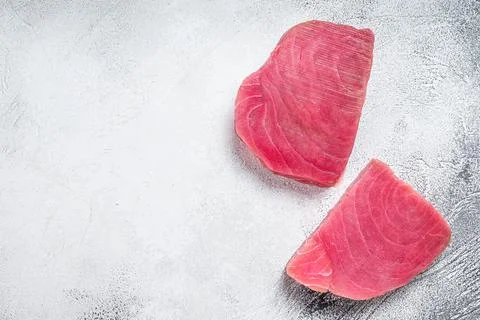 Two raw tuna steaks on rustic table. White background. Top view. Copy space Stock Photos