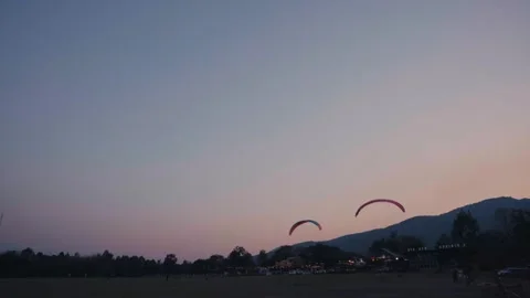Two RC Paragliders Flying At Dusk Against Mountain Silhouette Stock Footage 338355637
