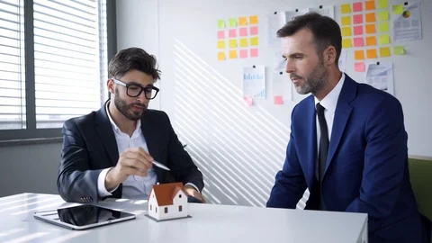 Two real estate developers discussing housing projects in office Stock Footage 114813922
