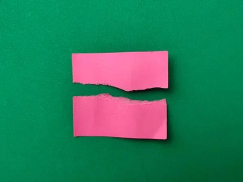 Two rectangular pieces of pink paper with rough, torn edges are placed para.. Stockfoto's