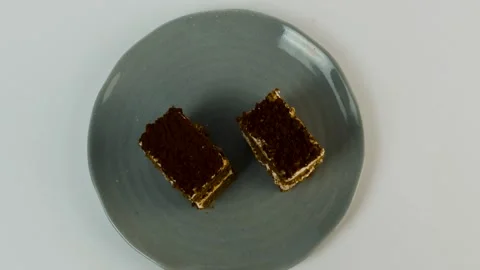 Two rectangular tiramisu pieces sit on a grey ceramic plate. Layers of coffee-so Stock Footage 309638099