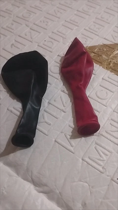 Two red and black rubber balloons have not yet been inflated Stock Footage 294733140