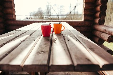 Two red and orange coffee cups on table outdoor, closeup Stock Photos