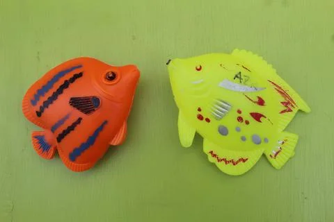 Two red and yellow toy fish Stock Photos