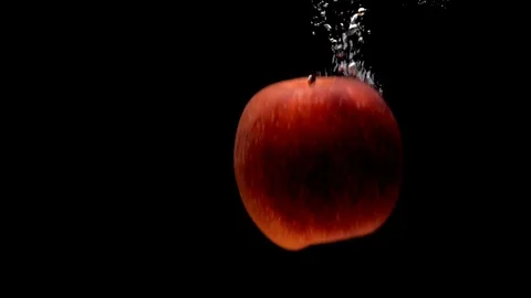 Two red apples falling into transparent water on black background Stock Footage 108783791