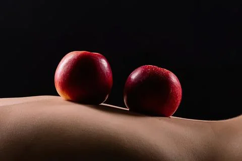 Two red apples on a smooth beige surface with dark background Stock Photos