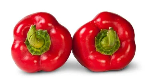 Two red bell peppers lying beside Stock Photos