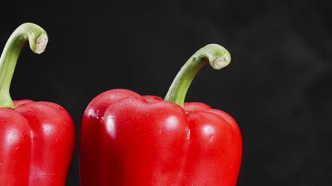 Two red bellpepper on black background with droplets Stock Footage 147283918