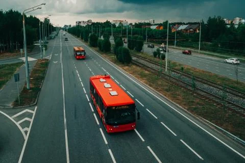 Two red buses on an empty road in Kazan. Stock Photos