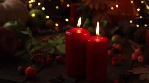 Two red candles on a wooden table among yellow lights, berries and ornaments. Stock Footage 164376984