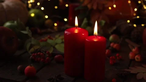 Two red candles on a wooden table among yellow lights, berries and ornaments. Stock Footage 164377002