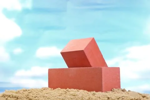 Two red ceramic bricks on the sand at the blue sky background Stock Photos