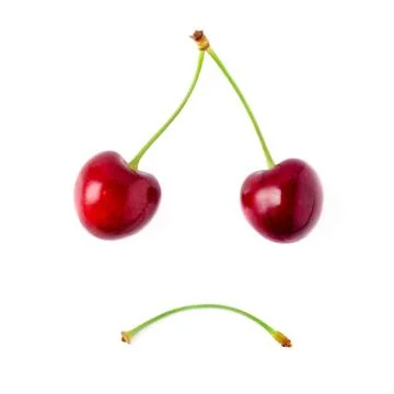 Two red cherries on a white background. The concept of sorrow. Stock Photos