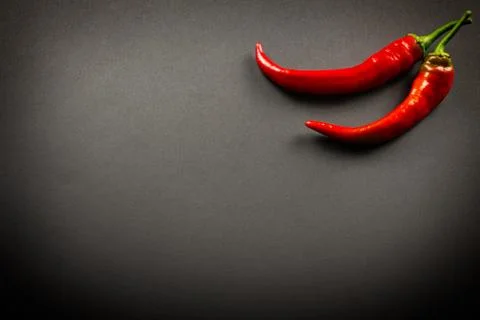 Two red chilli peppers on a black background Foto stock