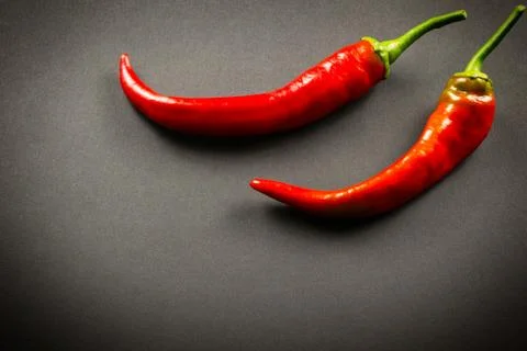 Two red chilli peppers on a black background Foto stock