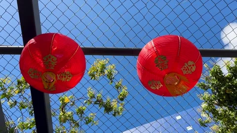 Two Red Chinese Lanterns Hanging Below Wire Mesh Fence Stock Footage 306135785