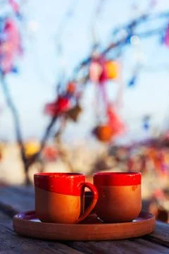Two red clay coffee cups placed on a tray on a wooden table Stock Photos