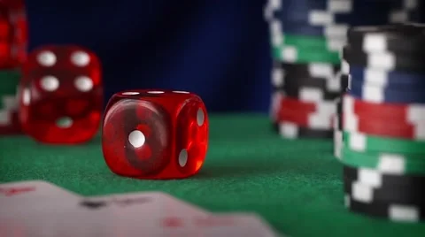 Two red dice rolls in hand, casino chips, cards on green felt Stock Footage 63329791