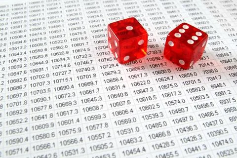 Two red dice on a spreadsheet financial data print out. Stockfoto's