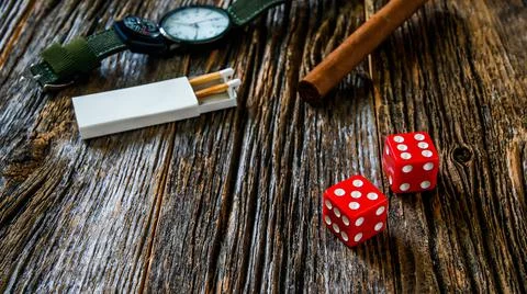 Two red dices on rustic old wooden table with other objects Stock Photos