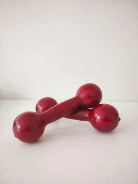 Two red dumbbells on a white background Stock Photos