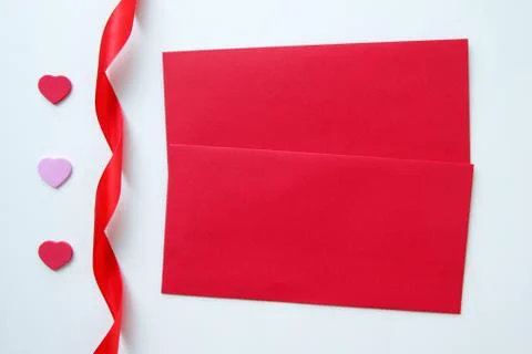 Two red envelopes with three hearts and ribbon for Valentine's Day. Stock Photos