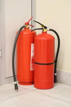 Two red fire extinguishers in an office or other public place. Fire protectio Stock Photos