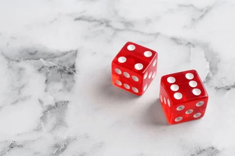 Two red game dices on white marble table. Space for text Stock Photos