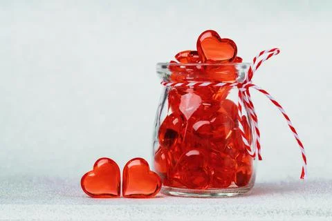 Two red glass hearts and a jar full of hearts Stock Photos