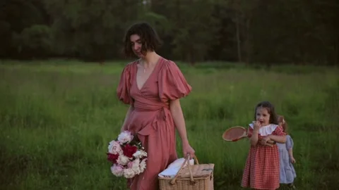 Two red-haired sisters and their mother walk across the field Video stock 218299415
