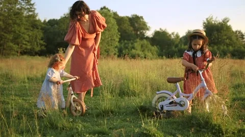 Two red-haired sisters and their mother walk across the field Video stock 218299910