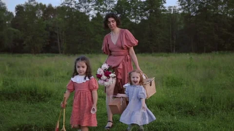 Two red-haired sisters and their mother walk across the field Video stock 218300443