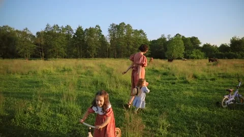 Two red-haired sisters and their mother run across the field Video stock 218300609