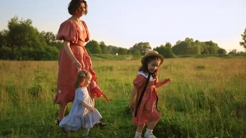 Two red-haired sisters and their mother walk across the field Video stock 218300622