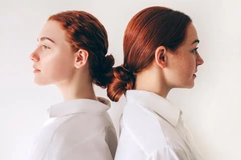 Two red-haired sisters stand isolated on a white background in shirts. Women Stock Photos
