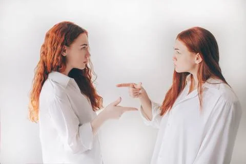Two red-haired sisters stand isolated on a white background in spacious Stock Photos