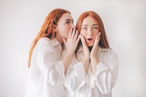 Two red-haired sisters stand isolated on a white background in spacious Stock Photos
