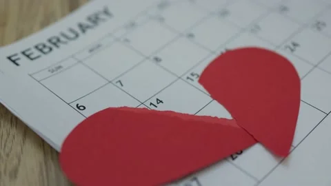 Two red halves paper heart falling down February month calendar. Valentines day Video stock 169112602