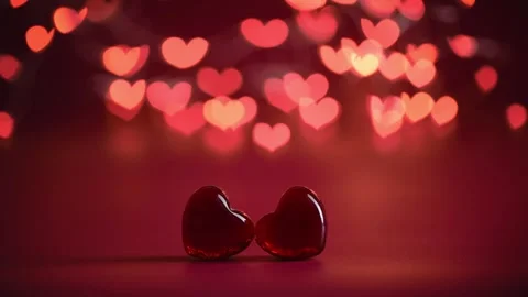 Two red heart-shaped objects rest against a vibrant red background Stock Footage 301297287