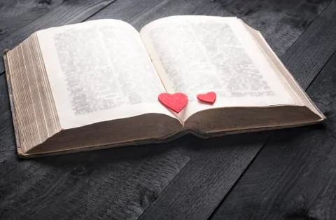 Two red hearts on an aged book Stock Photos