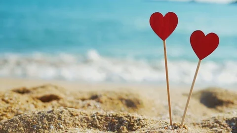 Two red hearts on the background of the surf in sunny weather. Видео 122245675