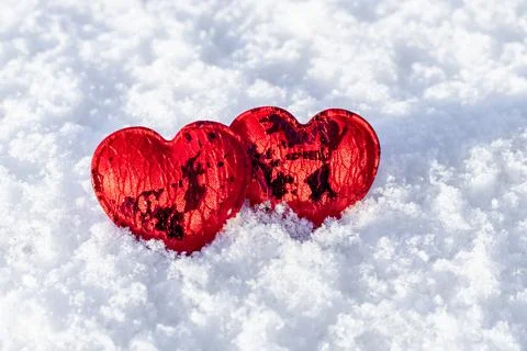 Two red hearts on a background of white snow close-up. Valentine's day concept Foto stock